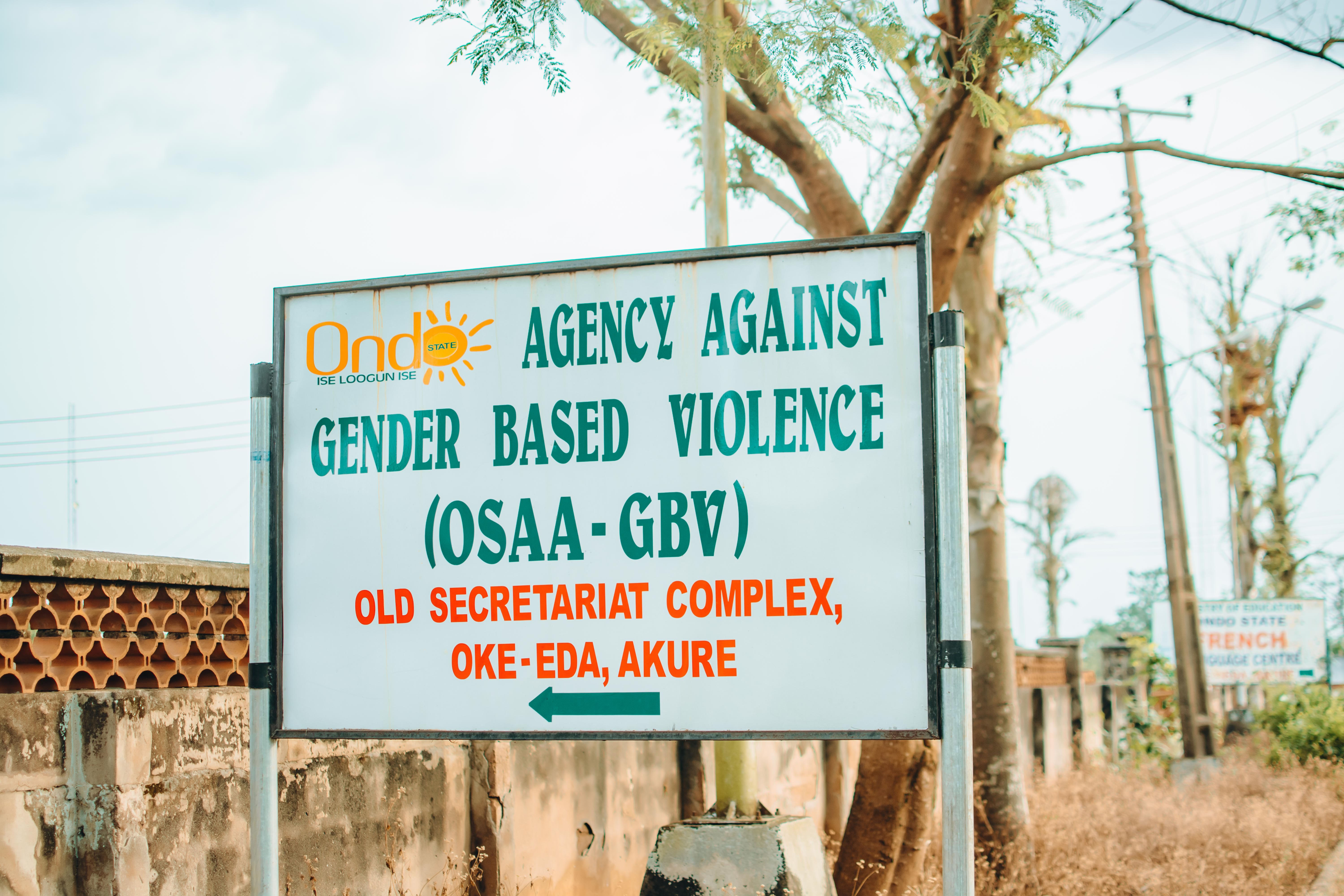 A large sign displaying the name of the Ondo State Agency Against Gender Based Violence and its address.