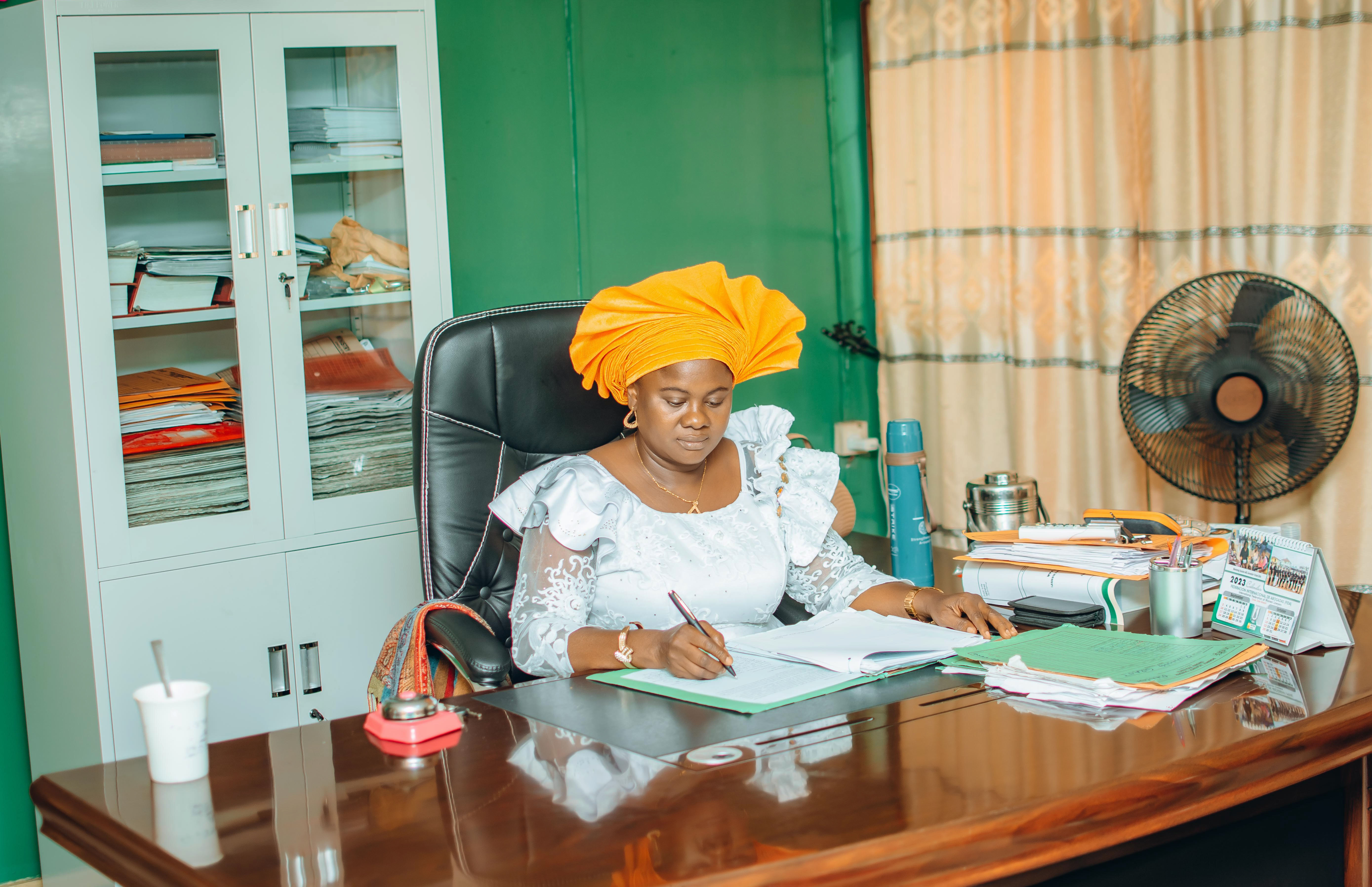 A woman sits at a desk writing